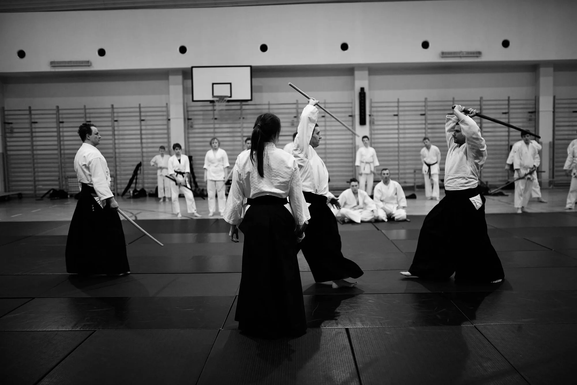 Trening aikido z bronią na macie w sali w Pruszkowie
